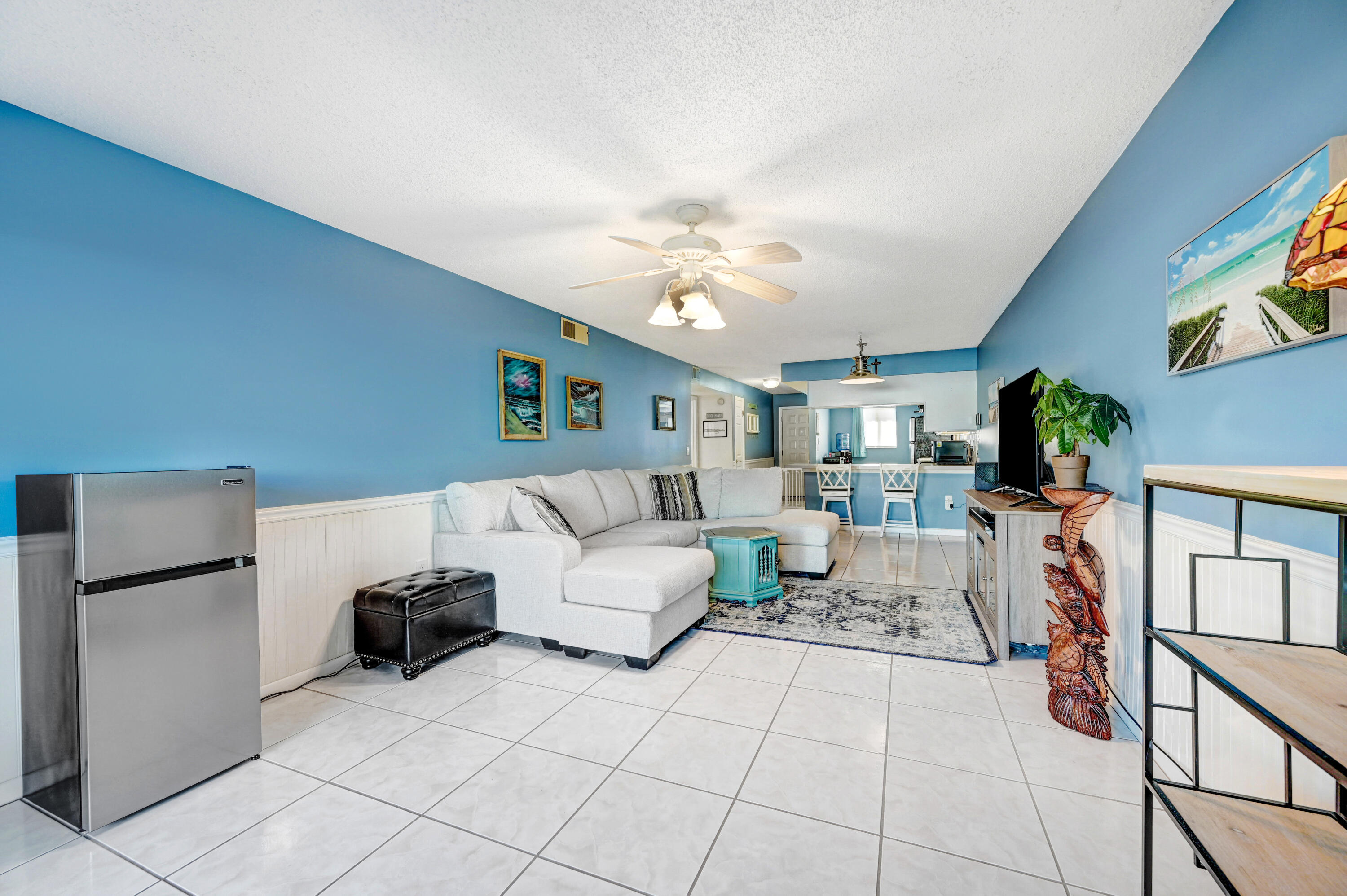 6655 Ridgewood Avenue, Unit 104 Cocoa Beach, FL 32931 - Photo 10 of 25 a living room with furniture and a chandelier