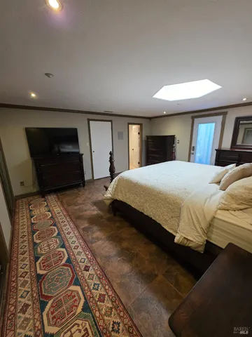 a bedroom with a large bed and a tv