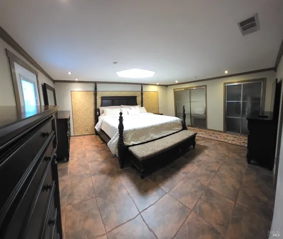 a bedroom with a bed and a view of closet