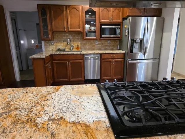 a kitchen with granite countertop a stove and a refrigerator