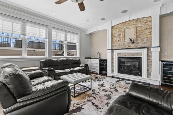 a living room with furniture a fireplace and a floor to ceiling window