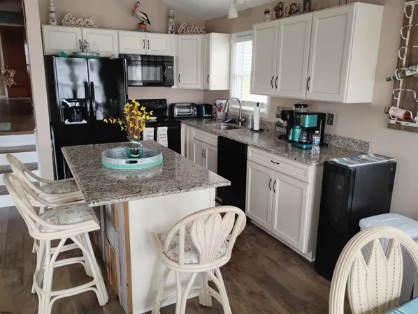 a kitchen with stainless steel appliances granite countertop a table chairs stove and cabinets
