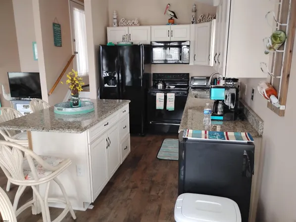 a kitchen with stainless steel appliances a microwave a refrigerator and chairs