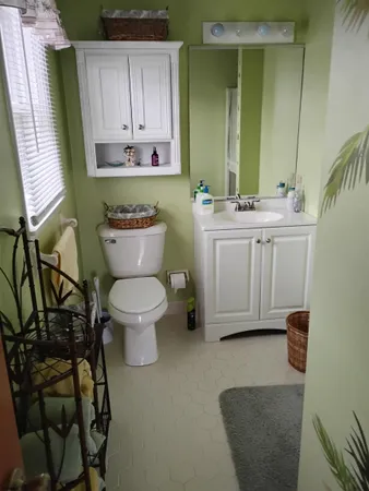 a bathroom with a toilet sink and mirror
