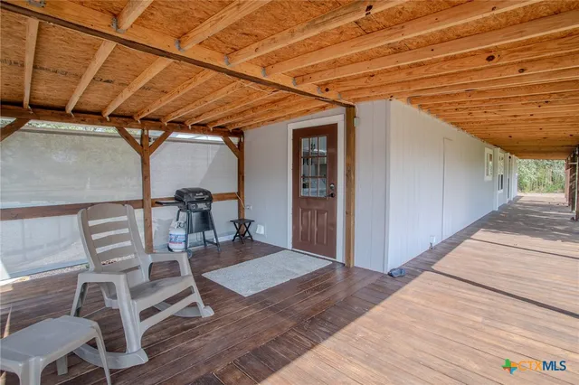 a view of a patio with table and chairs with wooden floor
