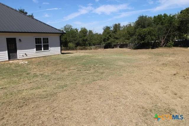a backyard of a house with table and chairs
