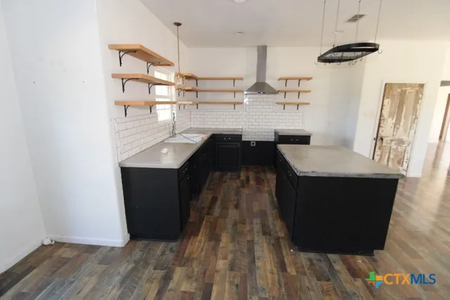 a kitchen with a sink and wooden floor