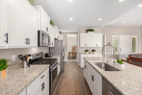 a large kitchen with stainless steel appliances granite countertop a lot of counter space and wooden cabinets