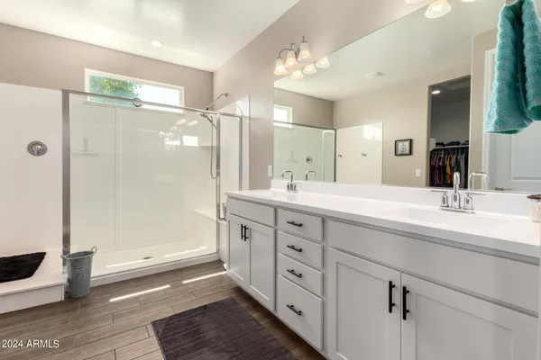 a spacious bathroom with double sink and shower