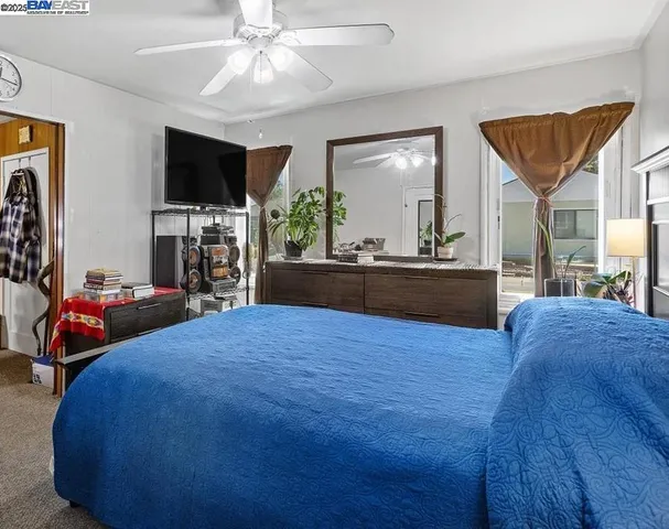 a bedroom with a bed and a flat tv screen on dresser