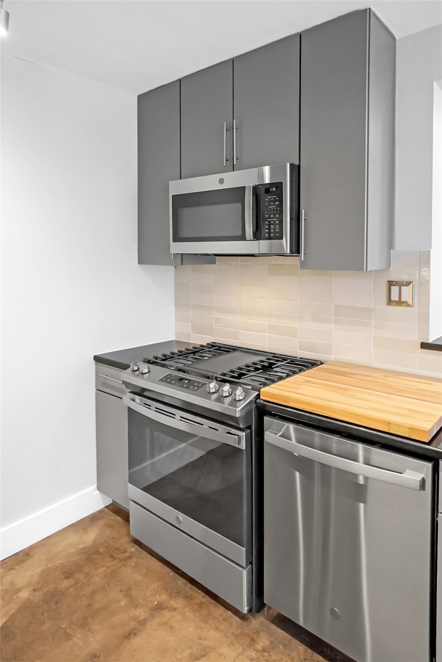 1212 Guadalupe Street, Unit 1004 Austin, TX 78701 - Photo 16 of 33 a kitchen with granite countertop a stove and a microwave