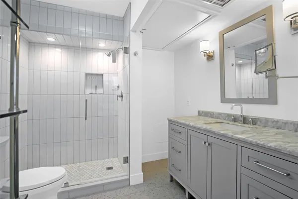 a bathroom with a granite countertop sink toilet and shower