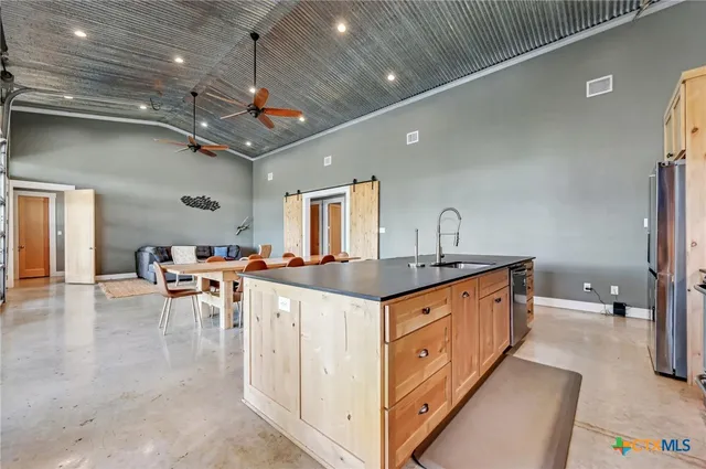 a kitchen with granite countertop a sink stove and cabinets