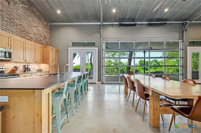 a view of a patio with a table and chairs next to a yard