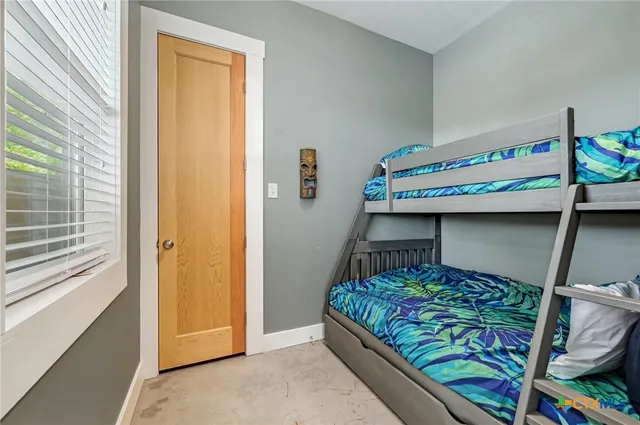 a bathroom with a toilet a sink a mirror and a window