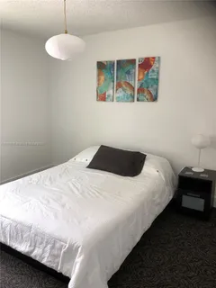 a bedroom with a bed and painting on the wall