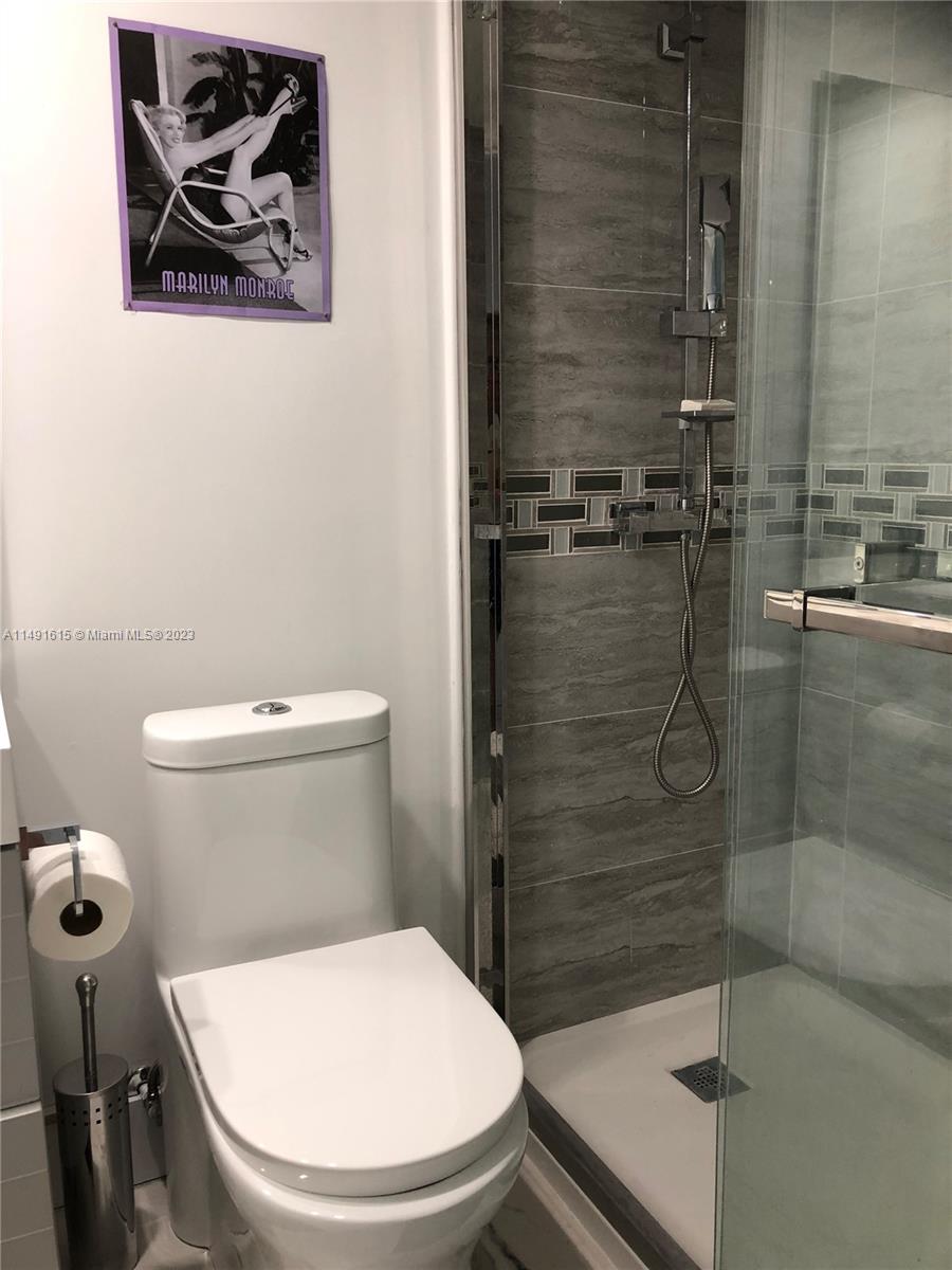427 Southwest 7th Street, Unit 15 Miami, FL 33130 - Photo 15 of 25 a white toilet sitting next to a bathroom sink and a shower