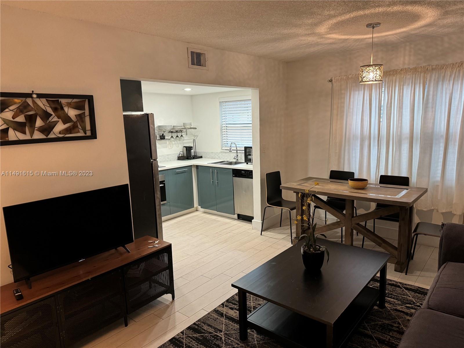 427 Southwest 7th Street, Unit 15 Miami, FL 33130 - Photo 16 of 25 a living room with furniture a flat screen tv and a dining table