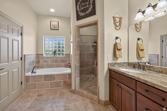 4635 East Sunny Acres Lane Moab, UT 84532 - Photo 52 of 56 Bathroom featuring a built-in soaking tub with a tiled surround, a glass block window, and a separate tiled shower