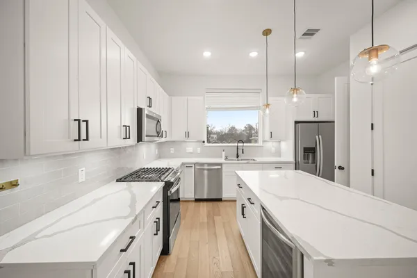 a kitchen with a sink a stove a refrigerator and cabinets