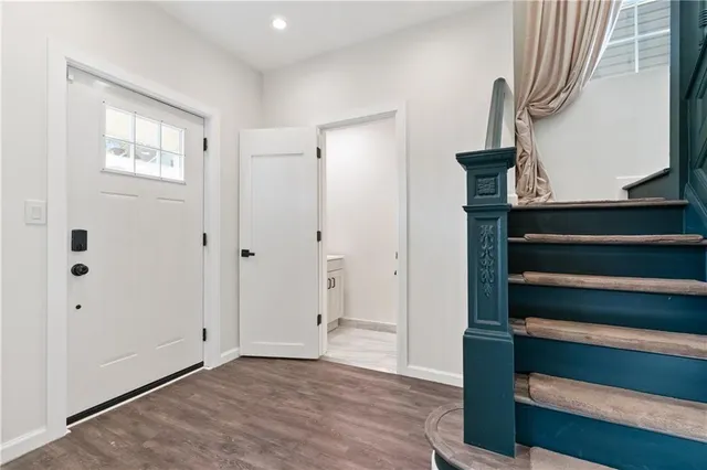 a view of front door with wooden floor and stairs