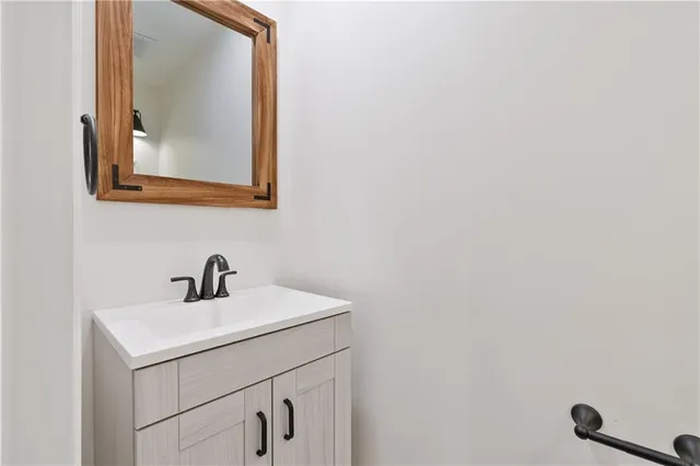 a bathroom with a sink a mirror and vanity