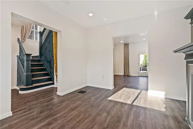 a view of a hallway with wooden floor and stairs