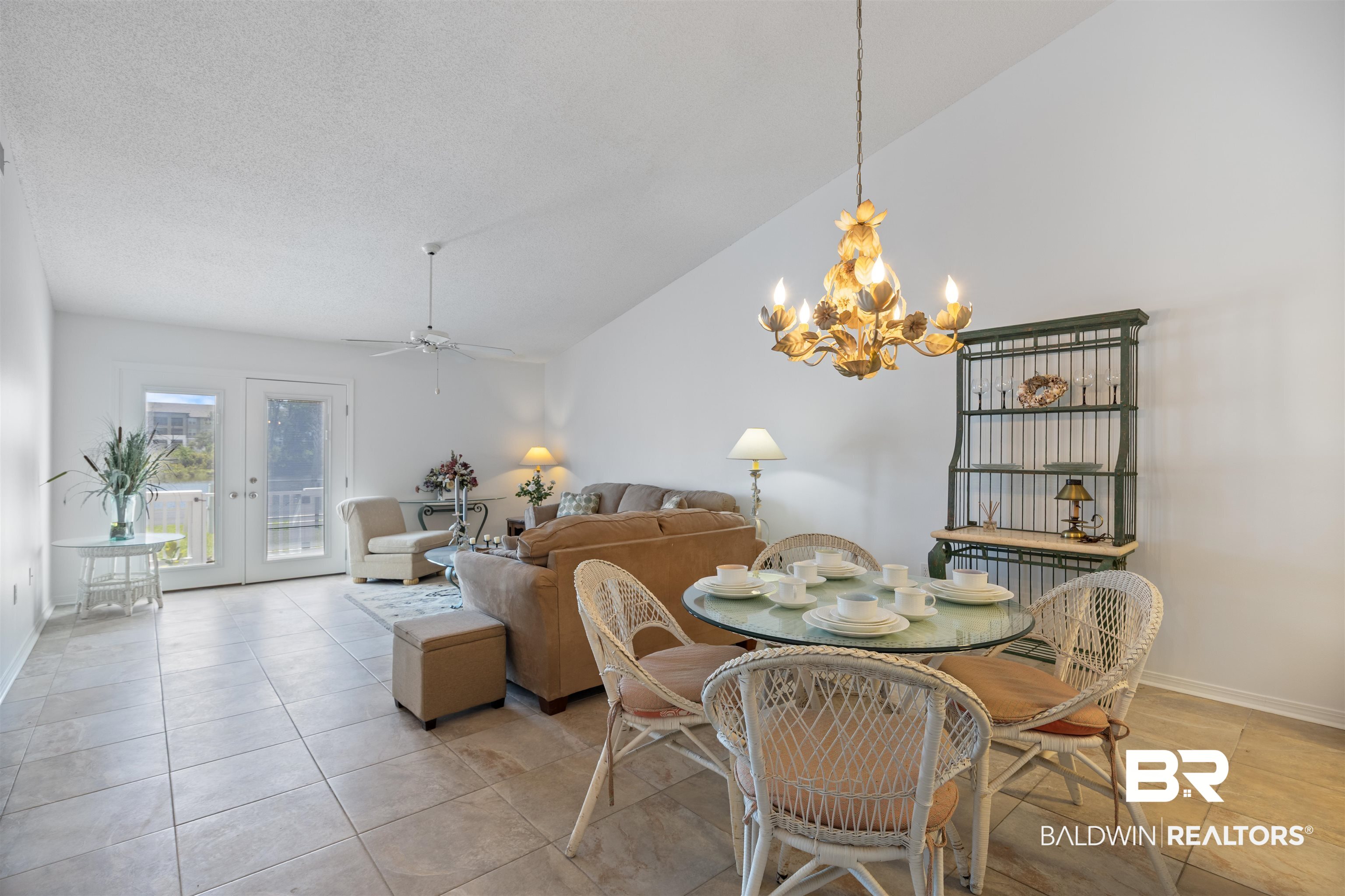3200 Loop Road, Unit 96 Orange Beach, AL 36561 - Photo 19 of 49 Vaulted ceiling living area featuring tile flooring, a decorative chandelier, and double French doors opening to an exterior space