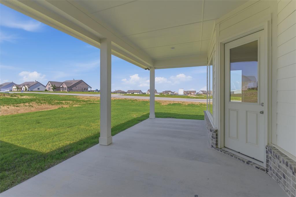 104 Snowy Owl Trail Rhome, TX 76078 - Photo 23 of 27 Covered concrete patio with white support columns