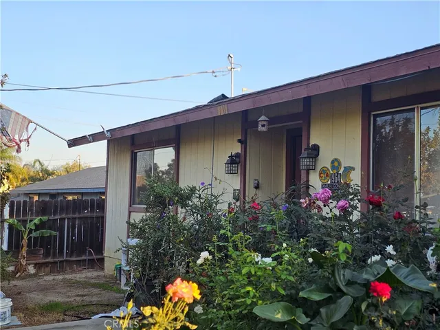 a front view of house and yard with beautiful flowers