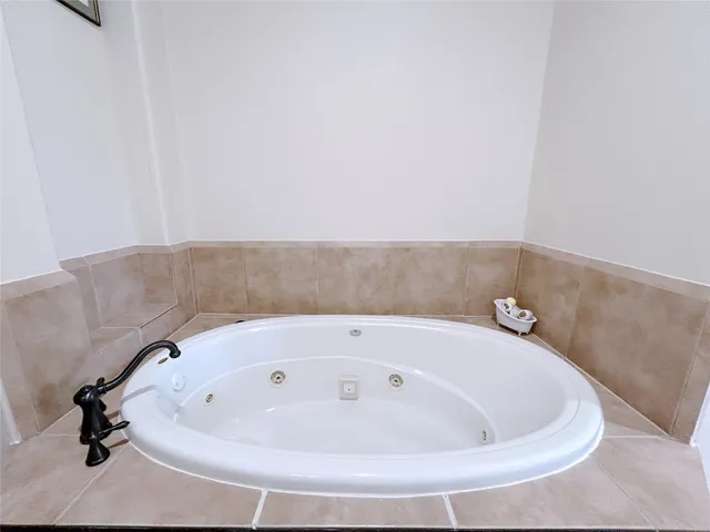 a bathroom with a tub a double vanity sink double and mirror