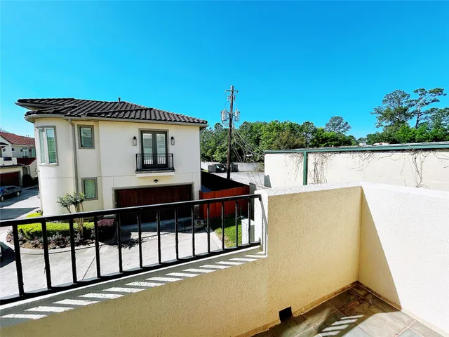 a view of a house with large windows and wooden fence