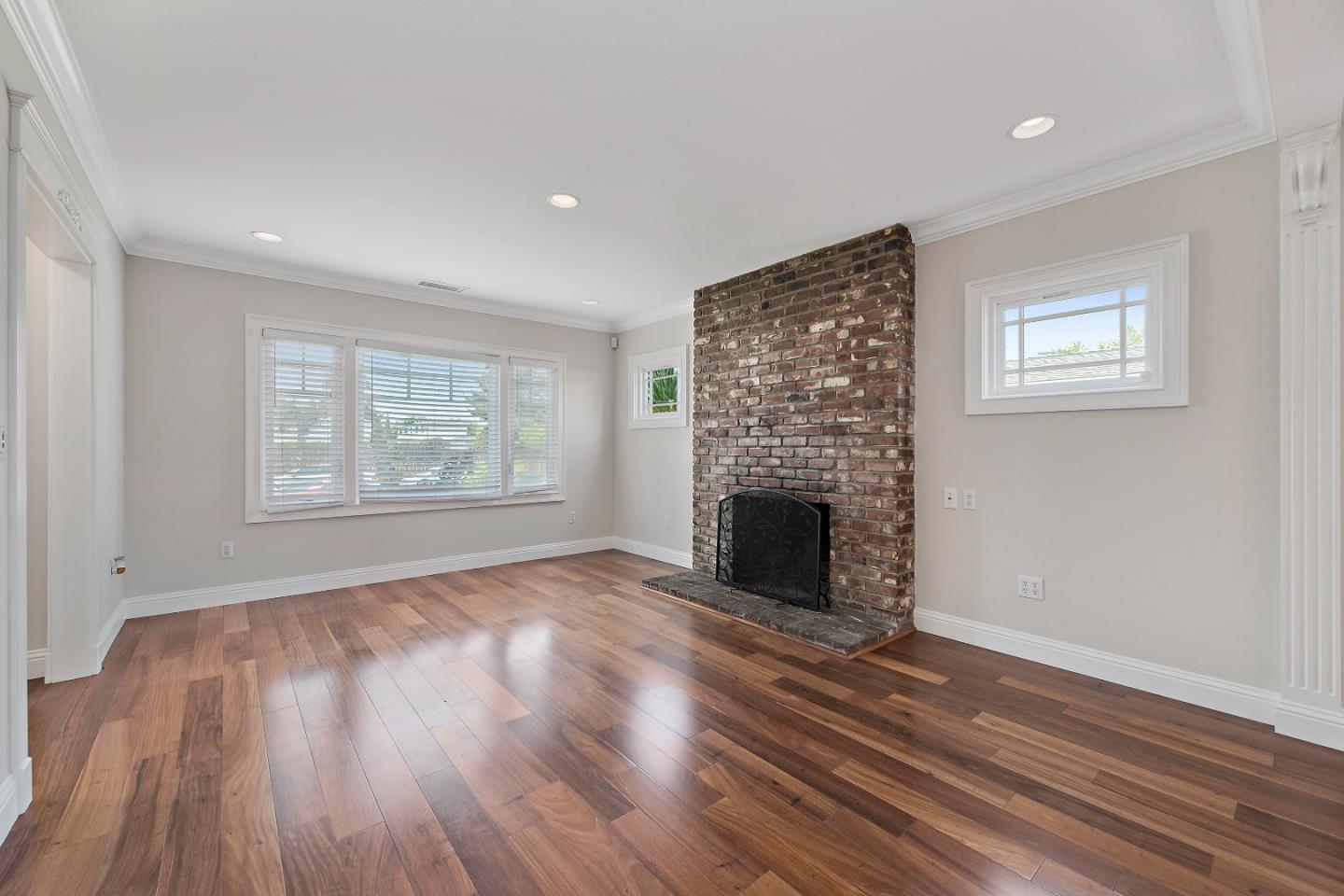 682 Second Avenue Redwood City, CA 94063 - Photo 5 of 18 an empty room with windows a fireplace and wooden floor