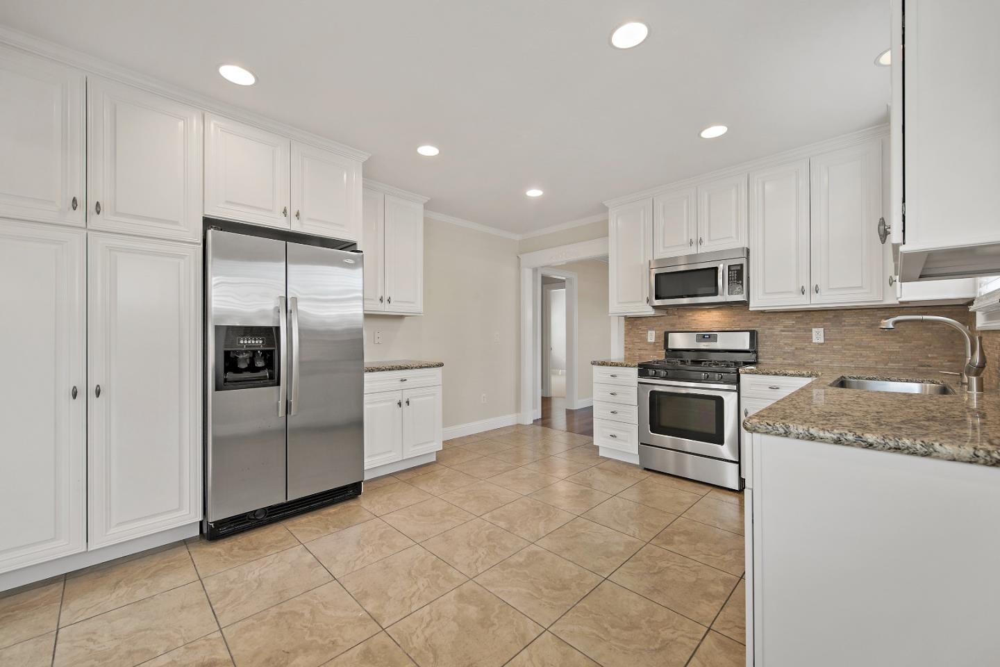 682 Second Avenue Redwood City, CA 94063 - Photo 10 of 18 a kitchen with kitchen island granite countertop stainless steel appliances and white cabinets