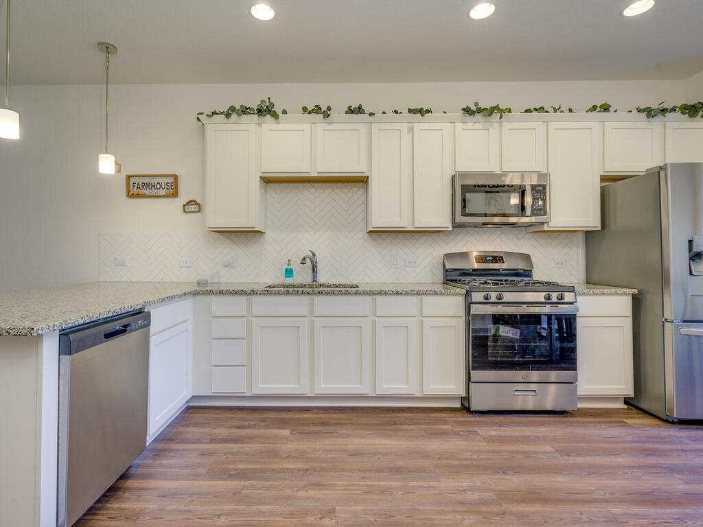 2257 Local Rebel Loop Leander, TX 78641 - Photo 10 of 26 a kitchen with stainless steel appliances a stove a sink and a refrigerator