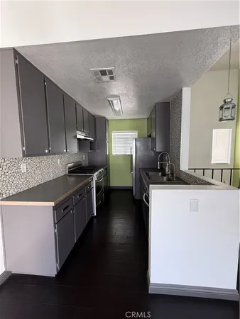 a kitchen with stainless steel appliances a sink stove and refrigerator