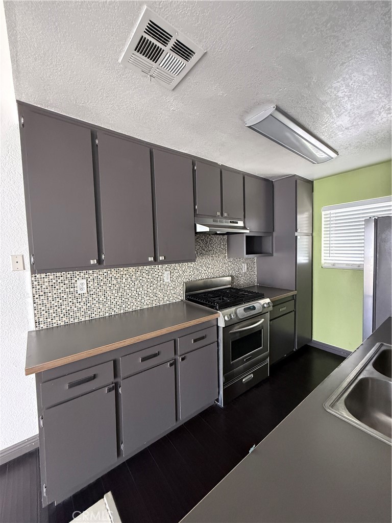24316 Sylvan Glen Road, Unit G Diamond Bar, CA 91765 - Photo 5 of 23 a kitchen with stainless steel appliances granite countertop a stove a sink and a refrigerator