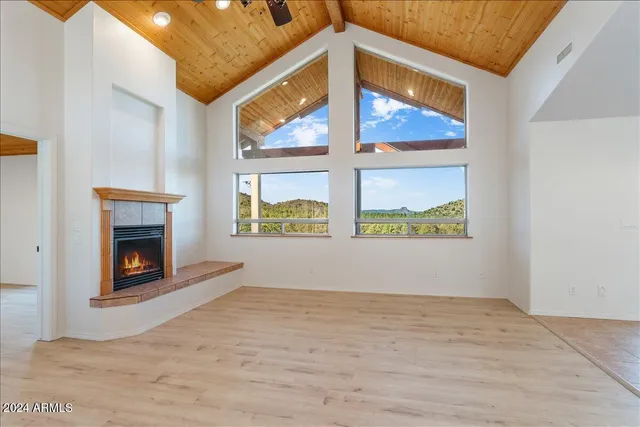 a view of an empty room with a fireplace and a window