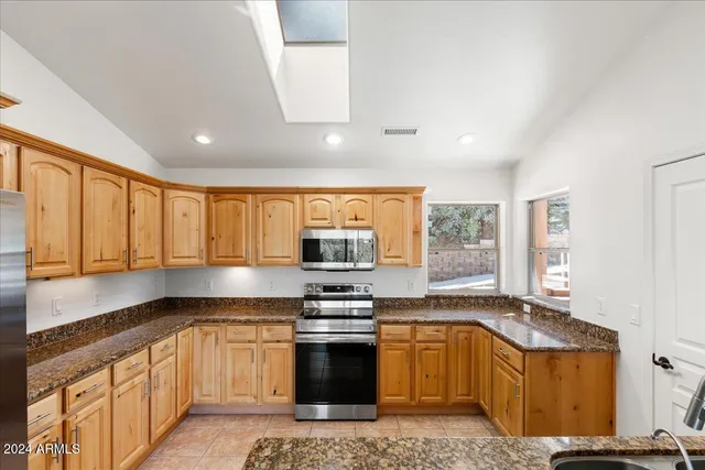 a kitchen with stainless steel appliances granite countertop a stove microwave and sink