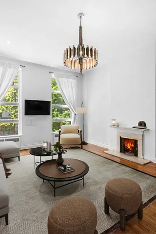 a living room with furniture chandelier and a window