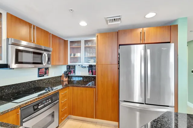 a kitchen with stainless steel appliances a refrigerator sink and microwave