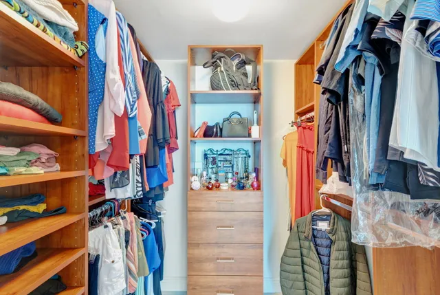 a view of walk in closet with clothes and shoes