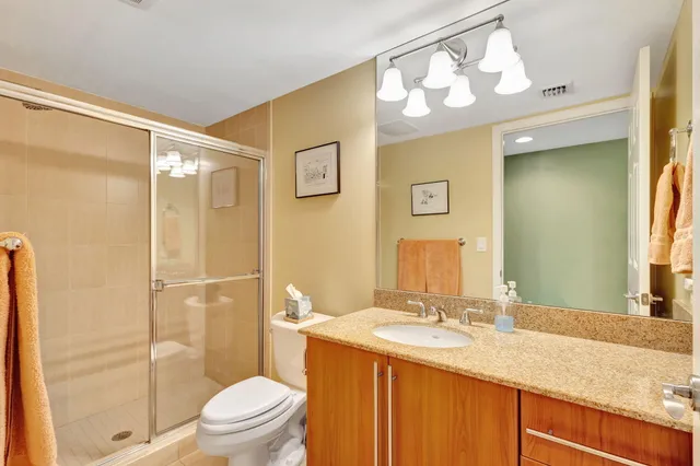 a bathroom with a granite countertop sink toilet and shower