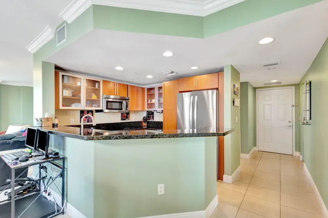 a kitchen with stainless steel appliances granite countertop a refrigerator and a stove