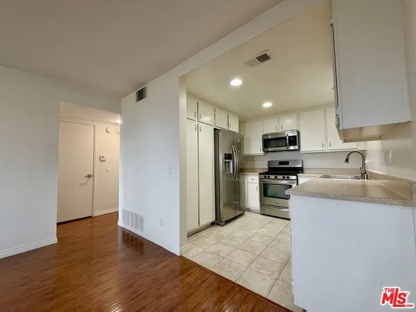 a kitchen with stainless steel appliances granite countertop a refrigerator sink and stove