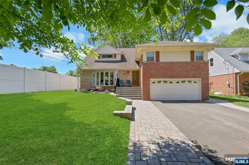 514 Rutland Avenue Teaneck, NJ 07666 - Photo 3 of 40 a front view of a house with a yard and garage