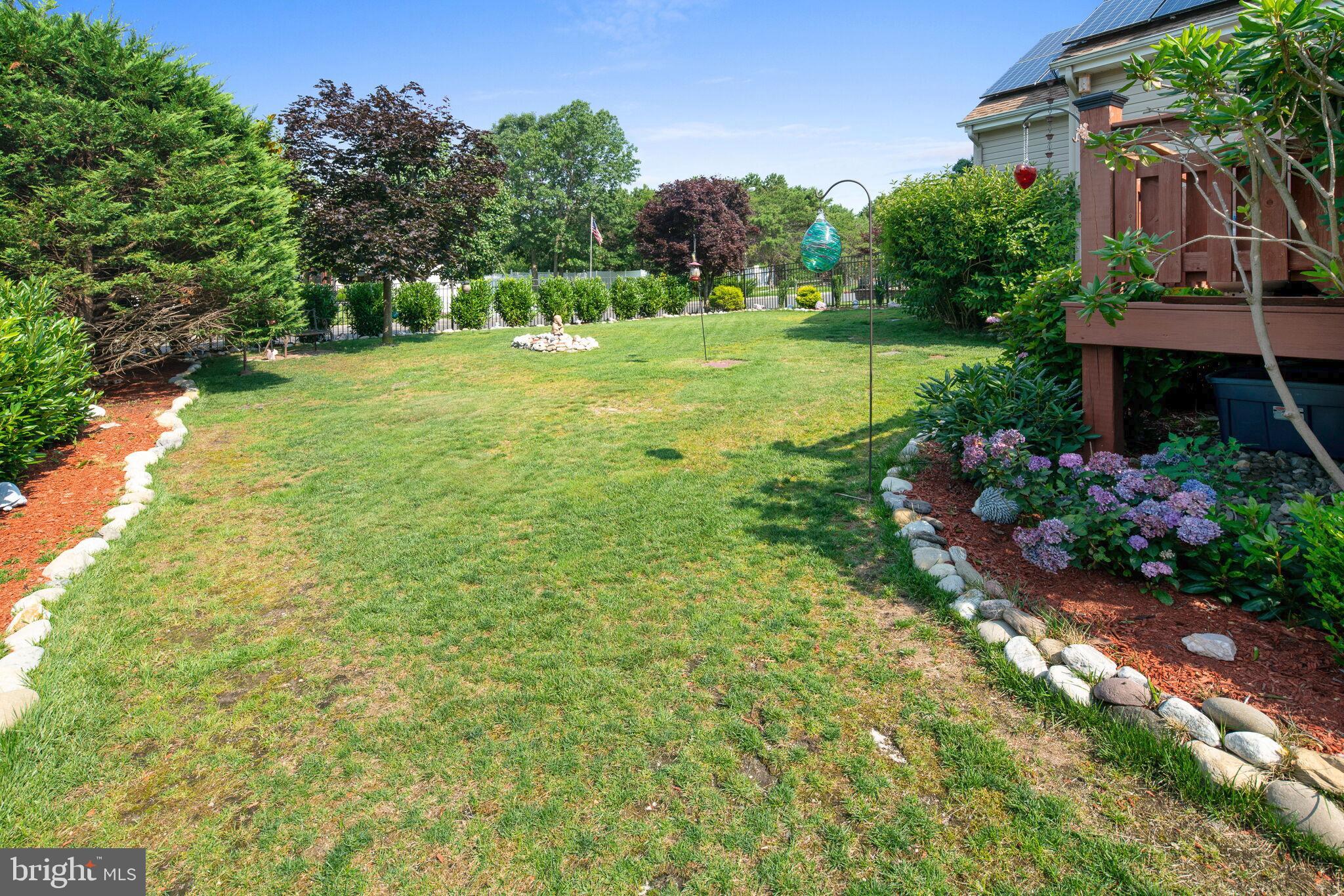 113 Swordfish Road Manahawkin, NJ 08050 - Photo 14 of 51 a view of a garden with a building in the background