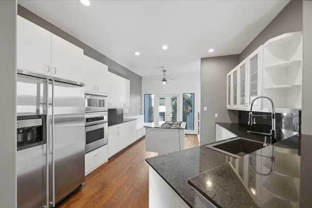 a kitchen with stainless steel appliances granite countertop a stove a sink and a refrigerator