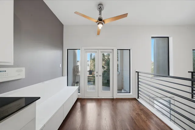 a view of a livingroom with wooden floor and a ceiling fan
