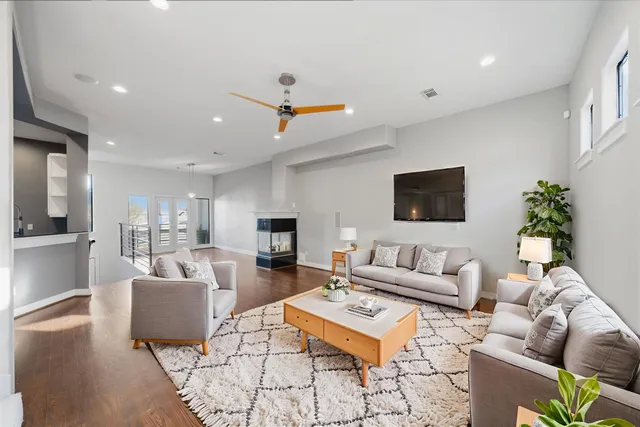 a living room with furniture kitchen view and a flat screen tv